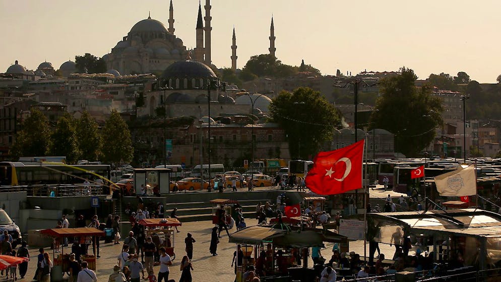 Menschen spazieren in der Nähe des Goldenen Horns, mit der Süleymaniye-Moschee im Hintergrund. Bei einem Brand in den Räumen eines Nachtclubs in Istanbul sind mindestens 25 Menschen getötet worden. Foto: Emrah Gurel/AP/dpa