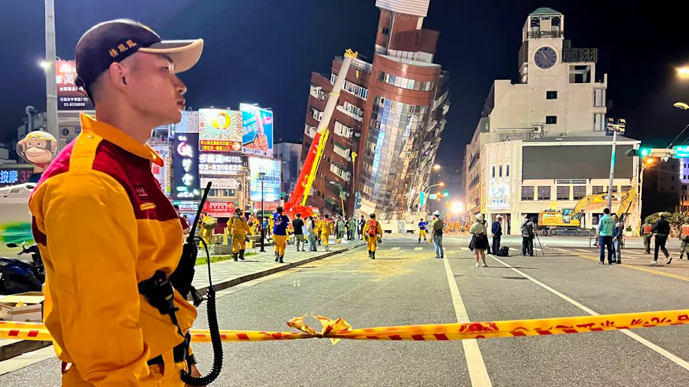 dpatopbilder - Ein Rettungshelfer steht in der Nähe der abgesperrten Stelle eines schiefen Gebäudes nach einem Erdbeben. Foto: Johnson Lai/AP/dpa