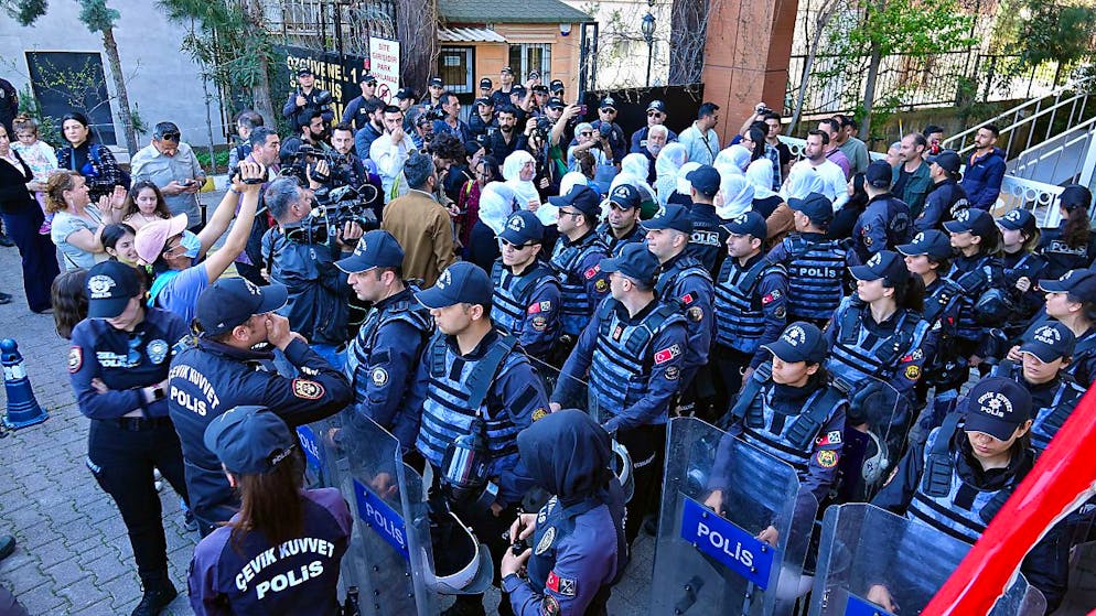 Eingekreist von Polizeibeamten protestieren Menschen gegen den nachträgliche Ausschluss des gewählten prokurdischen Bürgermeisters in der Stadt Van in der Türkei. Foto: Mehmet Masum Suer/SOPA Images via ZUMA Press Wire/dpa
