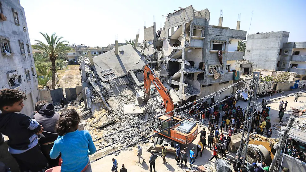 Palästinenser und Mitarbeiter des Zivilschutzes suchen in den Trümmern nach den Leichen von Palästinensern nach einem Bombenangriff israelischer Kampfflugzeuge auf das Haus der Familie Zorob. Foto: Mohammed Talatene/dpa