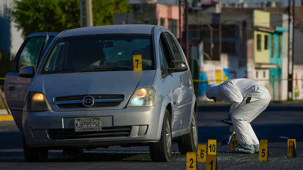 ARCHIV - Ein Polizeiermittler sammelt Beweise an der Stelle, an der ein Polizist in Celaya, Mexiko erschossen wurde. Foto: Fernando Llano/AP/dpa