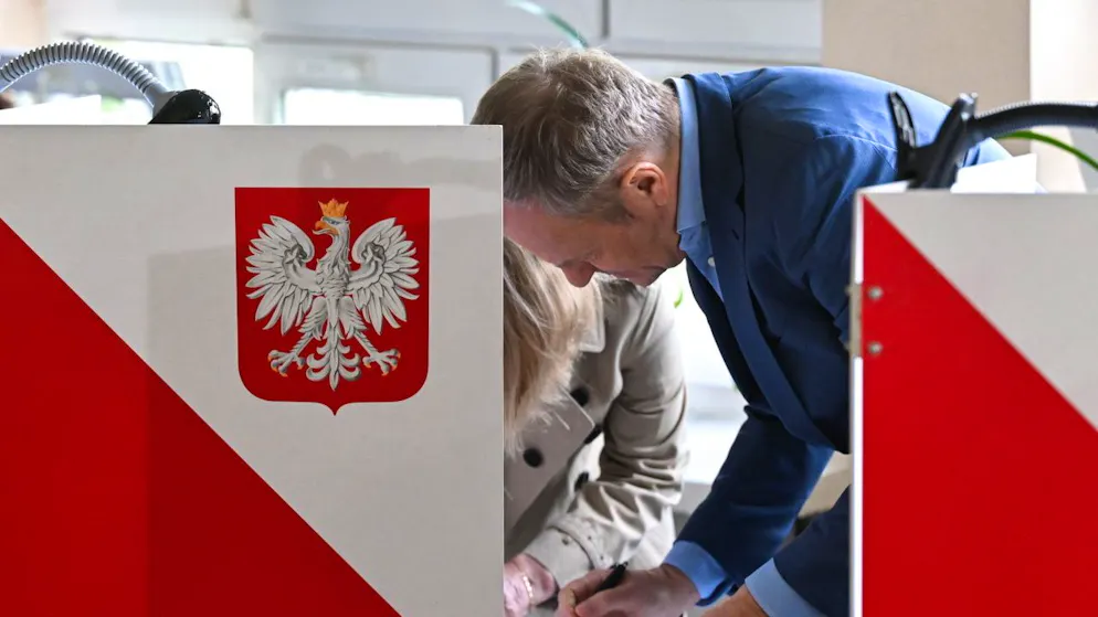 Le Premier ministre polonais, Donald Tusk, remplit son bulletin dans un local de vote dimanche lors des élections locales. La coalition pro-européenne dont il fait partie a réussi à maintenir son poids politique, malgré la victoire proportionnelle des nationalistes populistes.