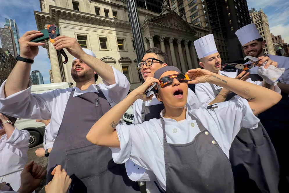 Millionen Menschen sehen totale Sonnenfinsternis - Gallery. Angestellte eines Restaurants im Flatiron District von Manhattan machen eine Pause, um die Sonnenfinsternis zu betrachten.