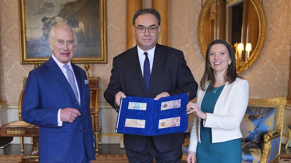 So sehen die ersten Banknoten mit König Charles III. aus. Und hier präsentieren Andrew Bailey, Gouverneur der Bank of England, zusammen mit Sarah John, der Exekutivdirektorin der Bank, die neuen Banknoten, die gedruckt worden sind.