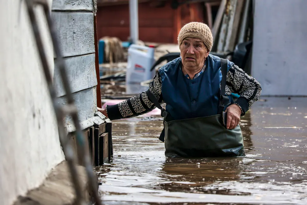 Eine Frau in der Nähe ihres Hauses in einem überschwemmten Gebiet in Orenburg, Russland.