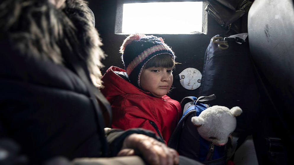 ARCHIV - Dieses von der Nachrichtenagentur AP am 21.03.2023 zur Verfügung gestellte Foto zeigt ein Mädchen, das mit seiner Mutter während der Evakuierung in einem Fahrzeug sitzt. Foto: Evgeniy Maloletka/AP/dpa