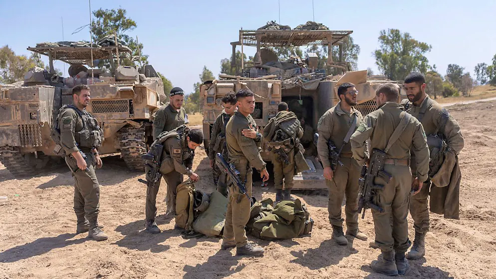 Israelische Soldaten stehen neben Mannschaftstransportern in der Nähe der Grenze zwischen Israel und Gaza, im Süden Israels. Bei den Beratungen des israelischen Kriegskabinetts sind einem Medienbericht zufolge mehrere Szenarien von Reaktionen auf den iranischen Großangriff besprochen worden. Foto: Ohad Zwigenberg/AP