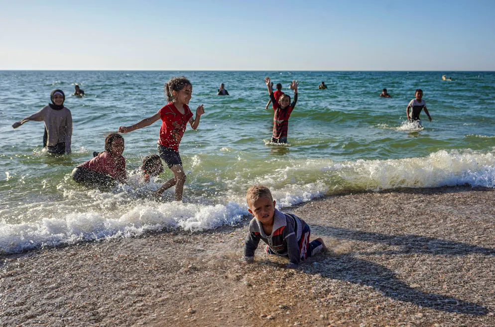 Des enfants palestiniens jouent sur une plage à Deir el-Balah, dans le centre de la bande de Gaza, le 17 avril 2024, dans le cadre du conflit entre Israël et le groupe militant Hamas. (Photo par AFP)