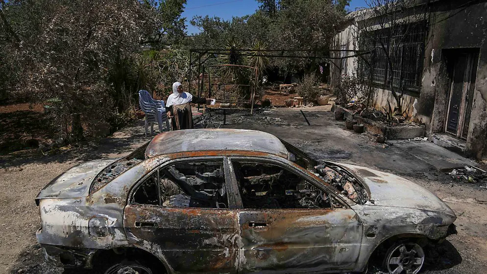 ARCHIV - Eine palästinensische Frau steht neben ihrem abgebrannten Haus, das von jüdischen Siedlern in Brand gesteckt worden war. Foto: Mahmoud Illean/AP/dpa