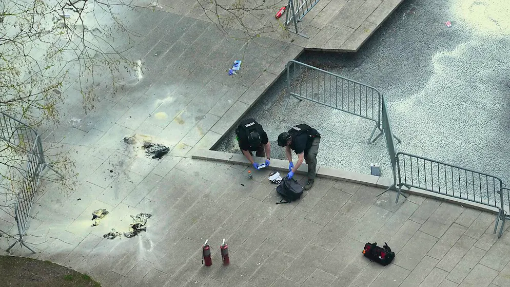 New Yorker Polizeibeamte inspizieren einen Rucksack an der Stelle im Collect Pond Park, wo sich ein Mann vor dem Strafgericht in Manhattan angezündet hat. Foto: Mary Altaffer/AP/dpa