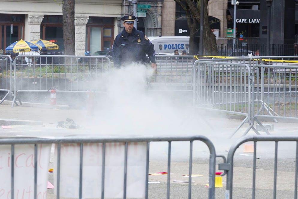 Un agente di polizia usa un estintore sulla scena in cui un uomo si è dato fuoco al Collect Pond Park, fuori dal tribunale penale di Manhattan, dove l'ex presidente Donald Trump sta partecipando alla selezione della giuria per il suo processo penale.