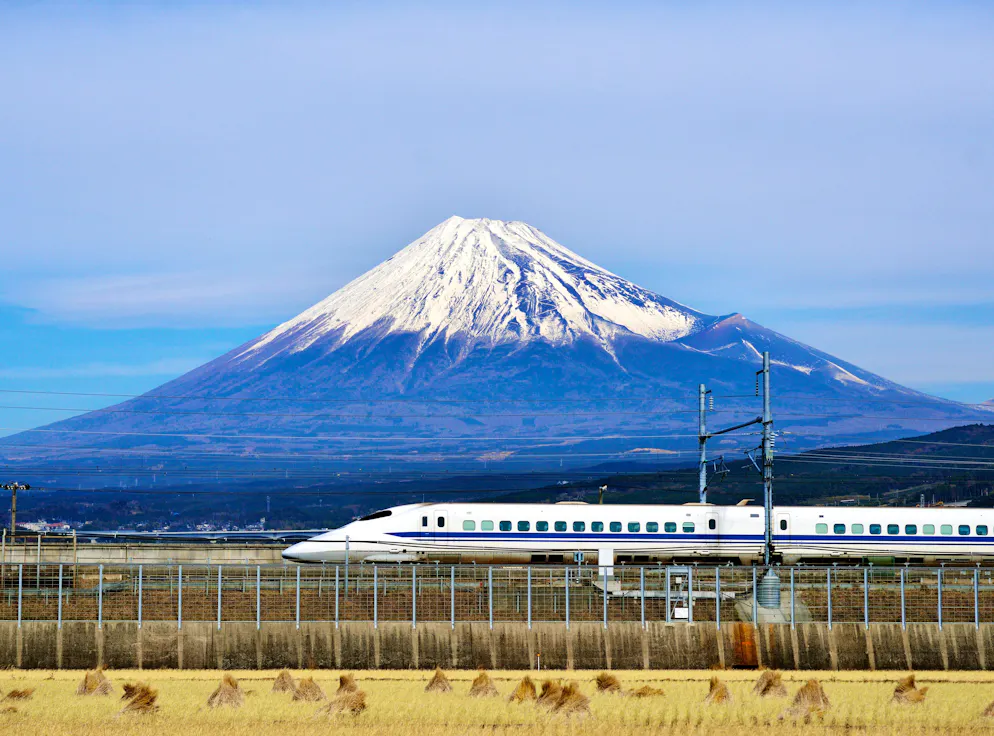 Ein Shinkansen auf der Bahnstrecke zwischen Tokyo und Osaka, im Hintergrund der Fuji.