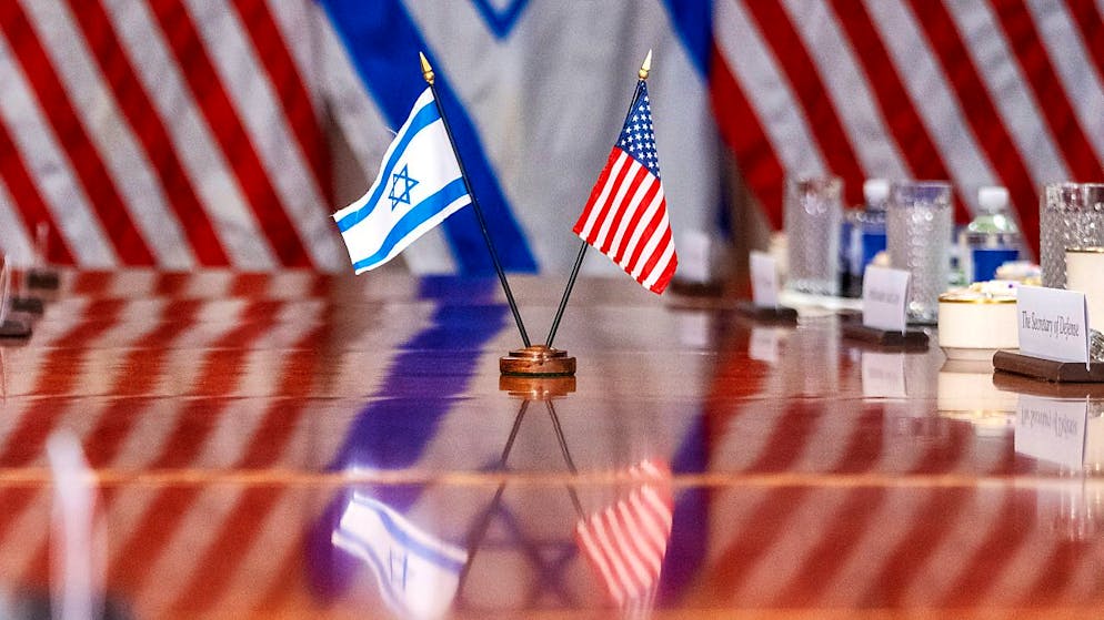 ARCHIV - Eine israelische und eine US-Flagge spiegeln sich auf einem Konferenztisch, während US-Verteidigungsminister Austin den israelischen Verteidigungsminister Galant im Pentagon trifft. Foto: Jacquelyn Martin/AP/dpa
