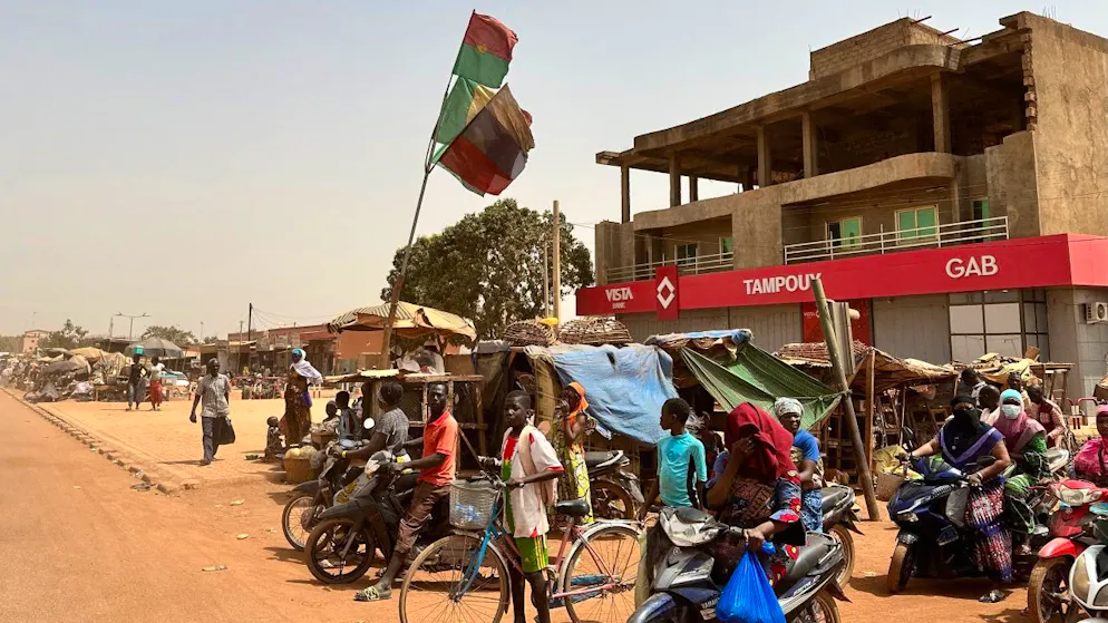 ARCHIV - Menschen stehen auf der Straße eines Vororts der burkinischen Hauptstadt Ouagadougou. Foto: Christina Peters/dpa-Zentralbild/dpa