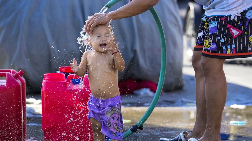L'unica cosa che aiuta è rinfrescarsi è un tubo d'acqua: le temperature estremamente calde nella capitale filippina Manila stanno rendendo quasi impossibile la normale vita quotidiana.