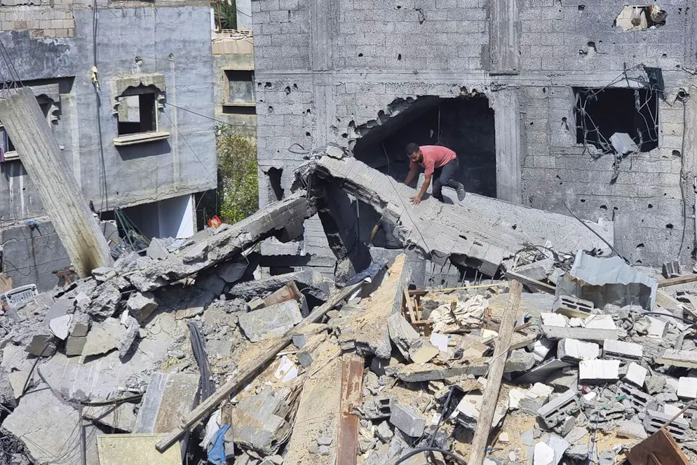 Palestinesi osservano la distruzione dopo un attacco aereo israeliano a Rafah, nella Striscia di Gaza. Lunedì 29 aprile 2024.