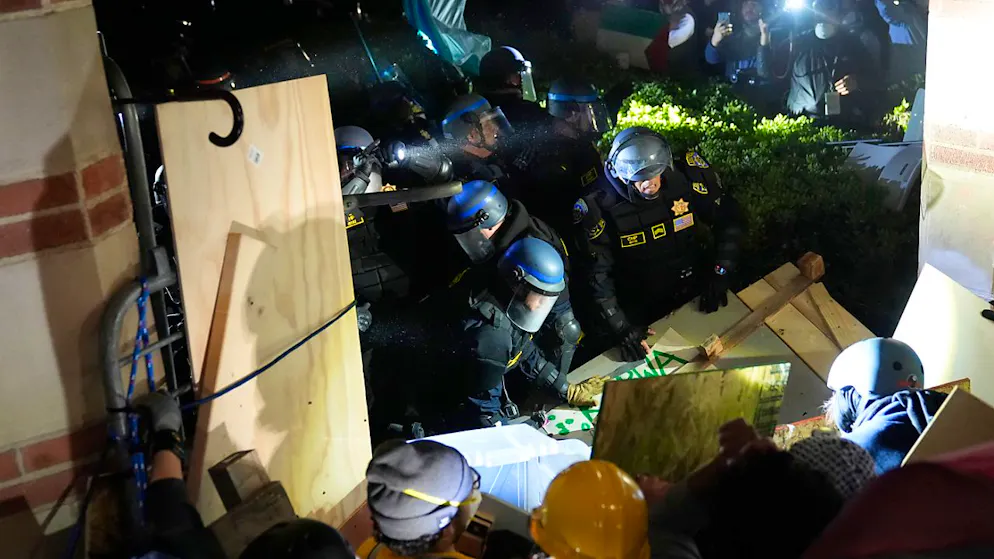 Die Polizei durchbricht eine Absperrung, die von pro-palästinensischen Demonstranten auf dem UCLA-Campus errichtet wurde. 