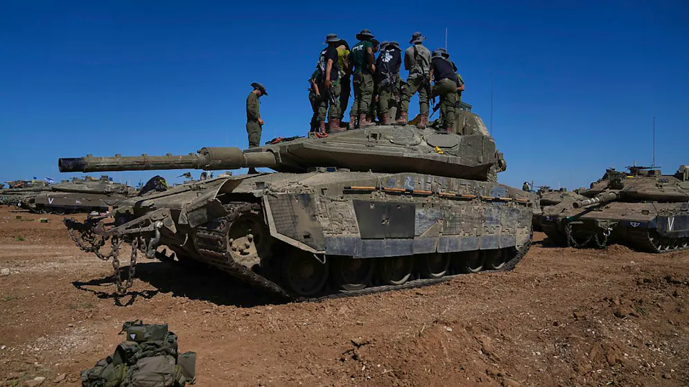 Israelische Soldaten stehen auf einem gepanzerten Militärfahrzeug an einem Rastplatz nahe der Grenze zwischen Israel und Gaza. Foto: Tsafrir Abayov/AP/dpa