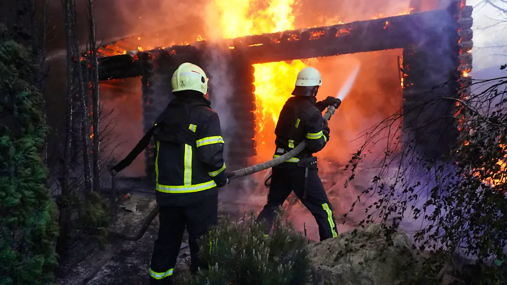 ARCHIV - Feuerwehrleute löschen ein Feuer, nachdem ein Haus von russischem Beschuss getroffen wurde. Foto: Andrii Marienko/AP/dpa