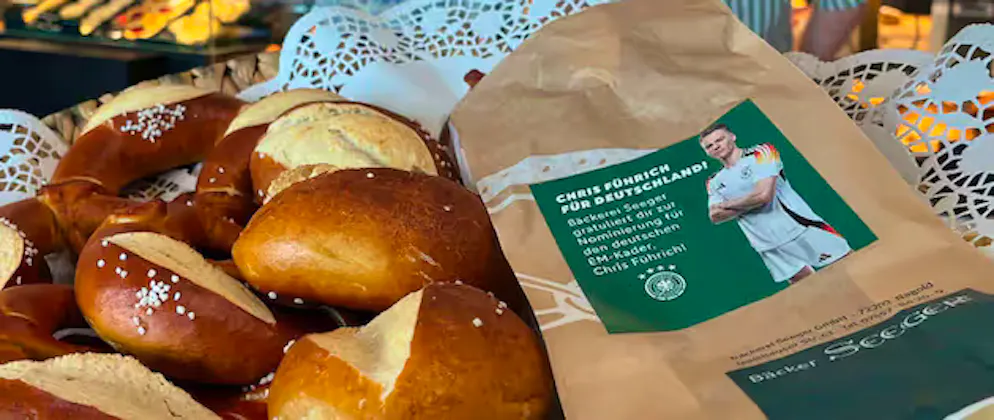 Führich lächelt den Bäckereikunden auf der Brottüte entgegen.