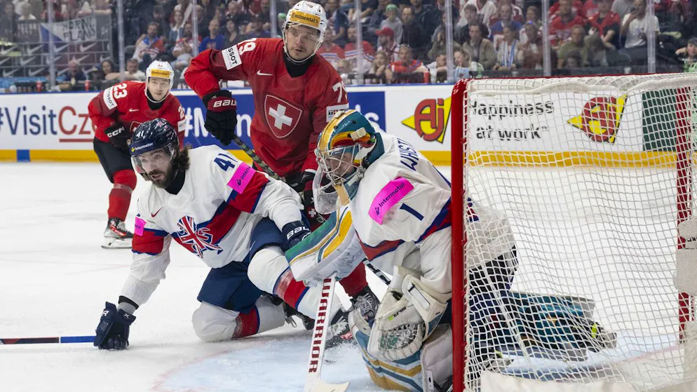 Switzerland's Calvin Thuerkauf, center, in action against Great Britain's Josh Batch, left, and Great Britain's goalkeeper Jackson Whistle during the Ice Hockey World Championship group A preliminary round match between Switzerland and Great Britain in Prague at the O2 Arena, Czech Republic, on Wednesday, May 15, 2024. (KEYSTONE/Peter Schneider)
