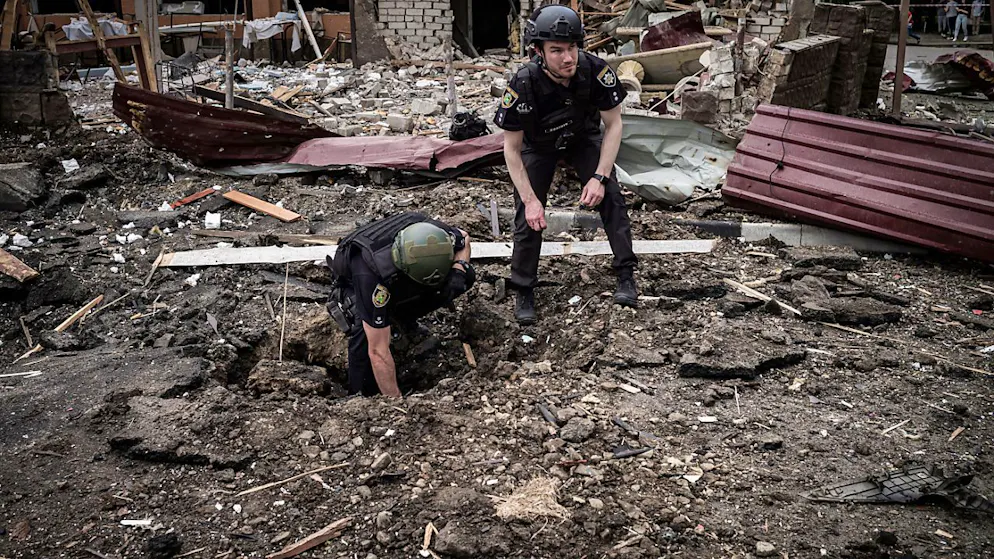 Militärs inspizieren einen Bombenkrater in einem Wohnviertel in Charkiw. Foto: Nicolas Cleuet/Le Pictorium via ZUMA Press/dpa