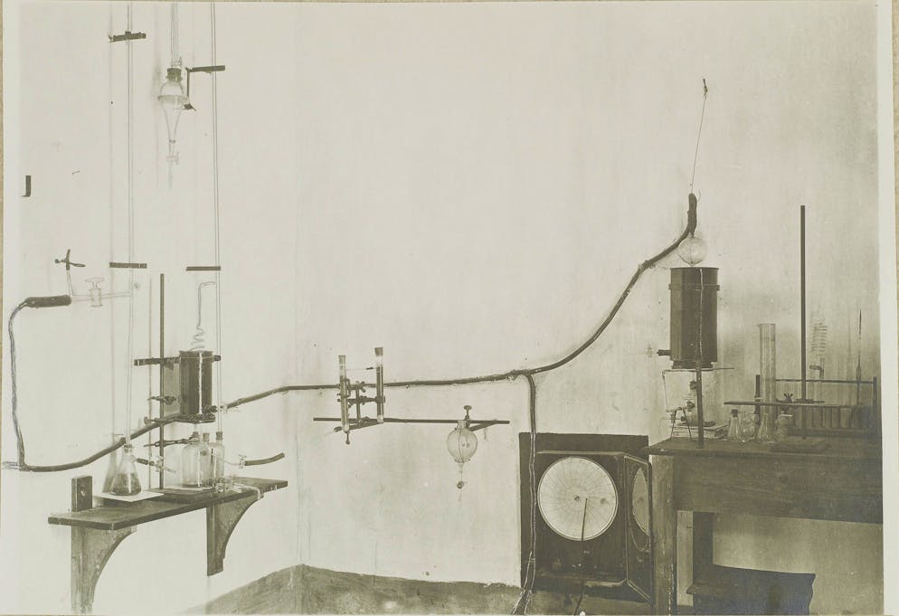 Immanuel Friedländer: Wer lebt hier denn so gefährlich?. Eine Messstation des Schweizerischen Vulkaninstitutes im Bereich der Solfatara in den Phlegräischen Feldern. Die Aufnahme zeigt das Innere des Observatoriums. Zu sehen: ein Apparat zum Auffangen und zur Beobachtung der Gase mit einem sogenannten Registrier-Thermometer.