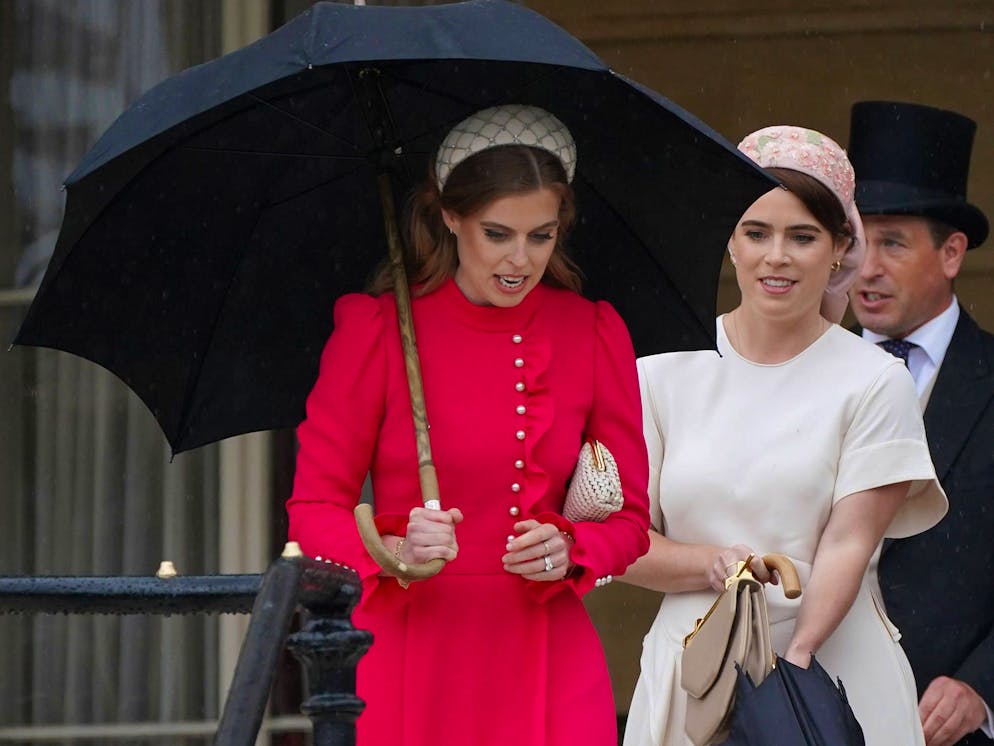 Princess Beatrice and Princess Eugenie stand next to their cousin Prince William during a Buckingham Palace garden party.