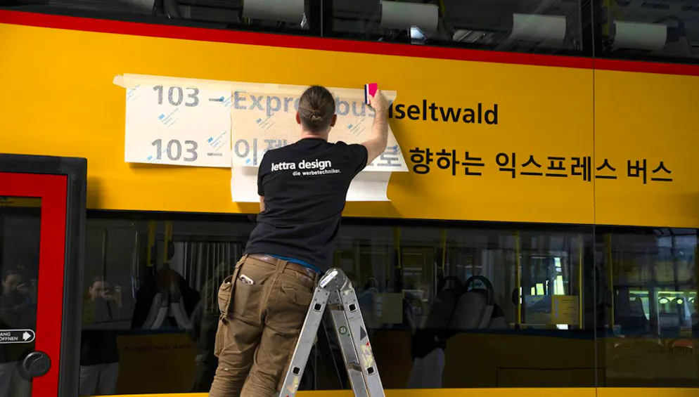 Postauto reagiert auf den Ansturm auf Iseltwald BE. Mit Postauto-Aufklebern, auf Bildschirmen und einer koreanischen Webseite sollen südkoreanische Tourist*innen andere Ziele schmackhaft gemacht werden.
