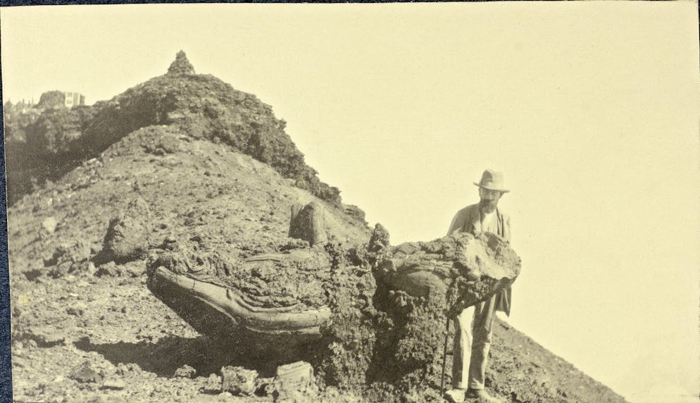 Immanuel Friedländer: Wer lebt hier denn so gefährlich?. So sieht eine vulkanische Bombe aus: Sie entsteht, wenn bei einem Vulkanausbruch Pyroklaster ballistisch herausgeschleudert wird. Diese Aufnahme zeigt Immanuel Friedländer neben einer ebensolchen am Fuji-Krater in Japan (1909).