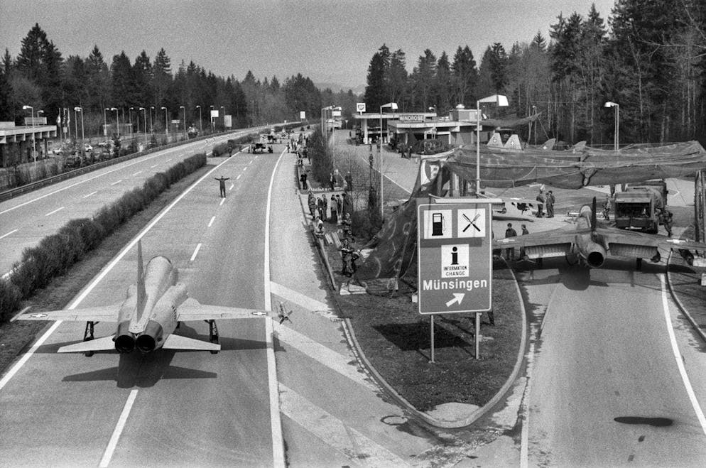 Esercitazioni storiche delle forze aeree sulle autostrade svizzere. A sinistra l'F-5 Tiger, a destra un Hawker Hunter all'ingresso di un'area di servizio autostradale.