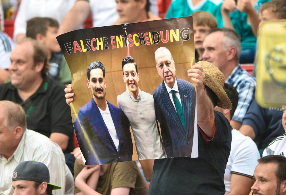 Un tifoso a Leverkusen con una foto di Özil e della controversa visita di Gündogan al primo ministro turco Erdogan.