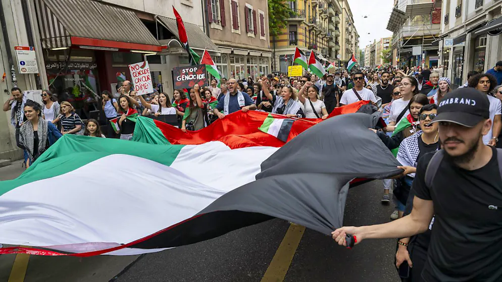 Al centro della manifestazione in favore della Palestina organizzata oggi a Ginevra, persone hanno sfilato con un'enorme bandiera palestinese.