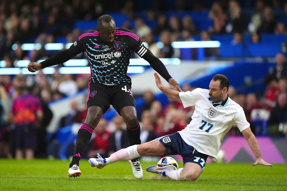 Usain Bolt (sinistra) in un contrasto con l'inglese Danny Dyer