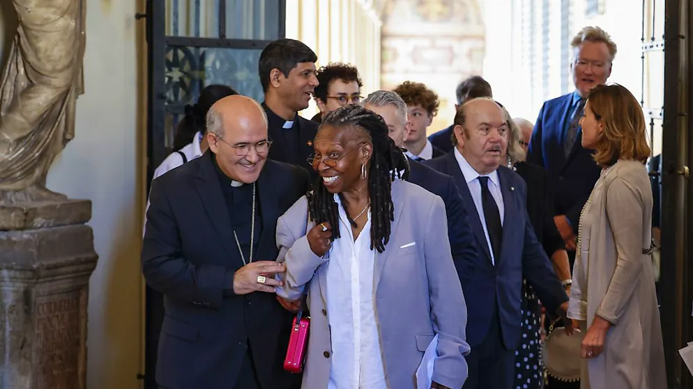 Whoopi Goldberg lascia la Cappella Sistina dopo l'incontro dei comici con Papa Francesco. Dietro di lei si intravvedono, tra gli altri, Lino Banfi e Conan O'Brien.