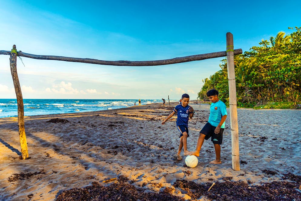 Costa Rica: il Parco nazionale del Tortuguero. I bambini del posto passano il tempo giocando a calcio sulla spiaggia.