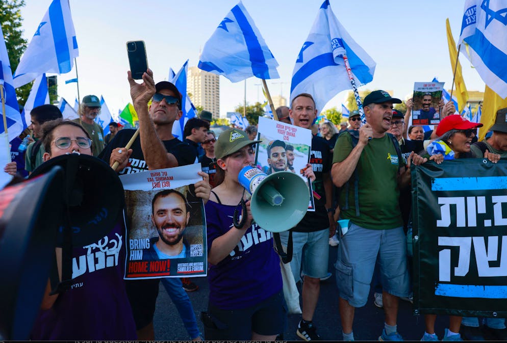 Des personnes brandissent des portraits d'Israéliens retenus en otage à Gaza, lors d'un rassemblement anti-gouvernement devant le Parlement israélien à Jérusalem.