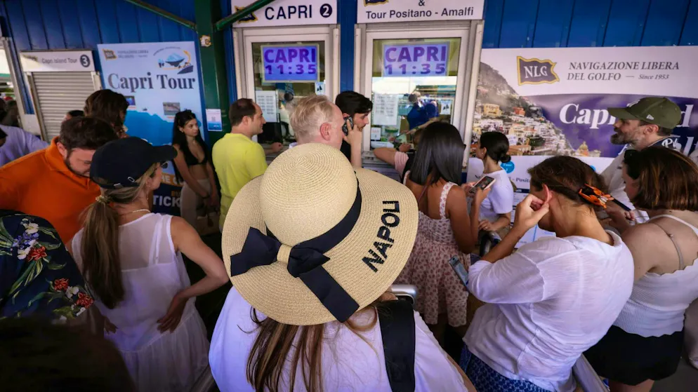 Travelers crowd in front of ticket counters at the Molo Beverello for the ferries that go to Capri, among other places. Tourists are now allowed back on the island.