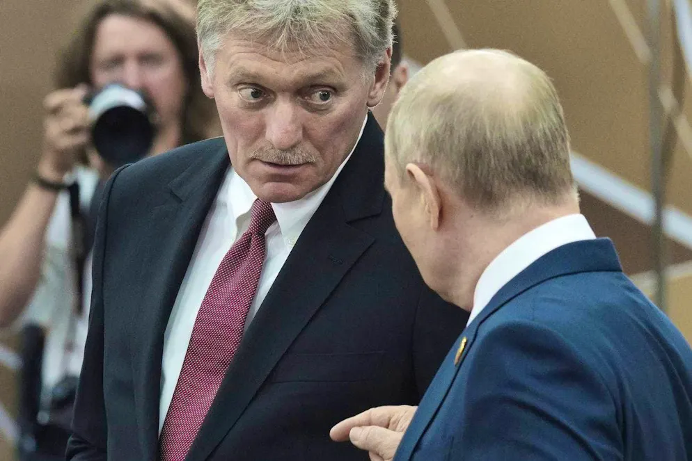 Dmitry Peskov (center) in conversation with Vladimir Putin.