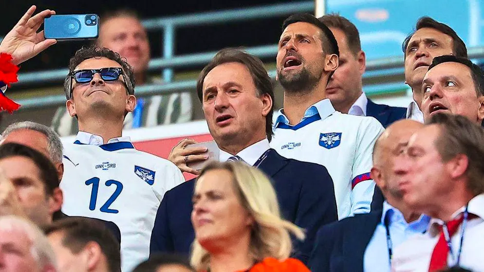 Novak Djokovic watches his Serbs' performance in the stadium.