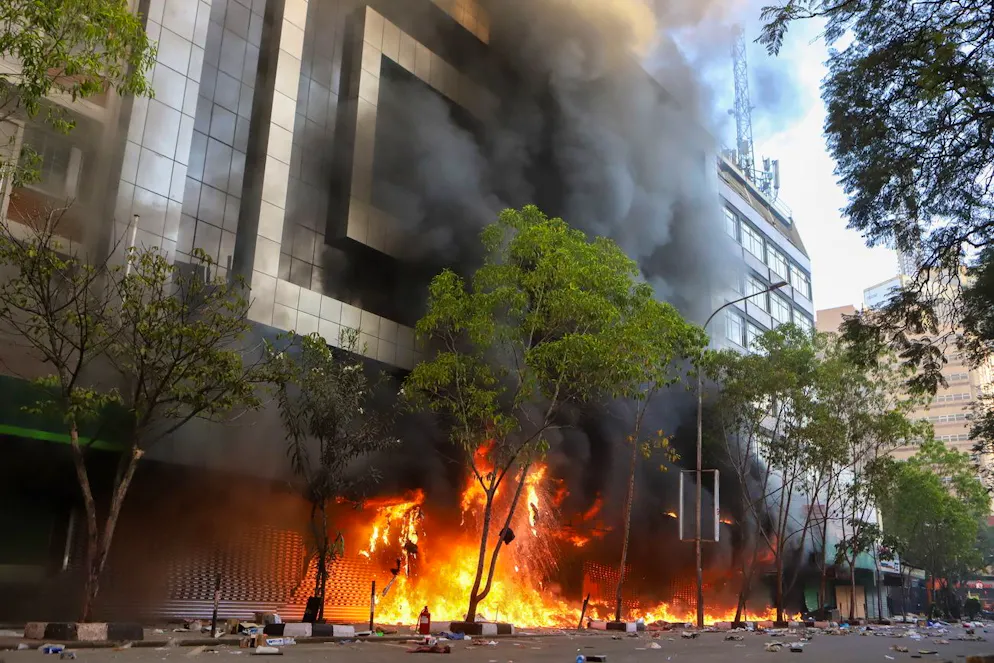 Fiamme e fumo fuoriescono da un centro commerciale in fiamme durante una protesta vicino al Parlamento contro gli aumenti delle tasse, a Nairobi, in Kenya.