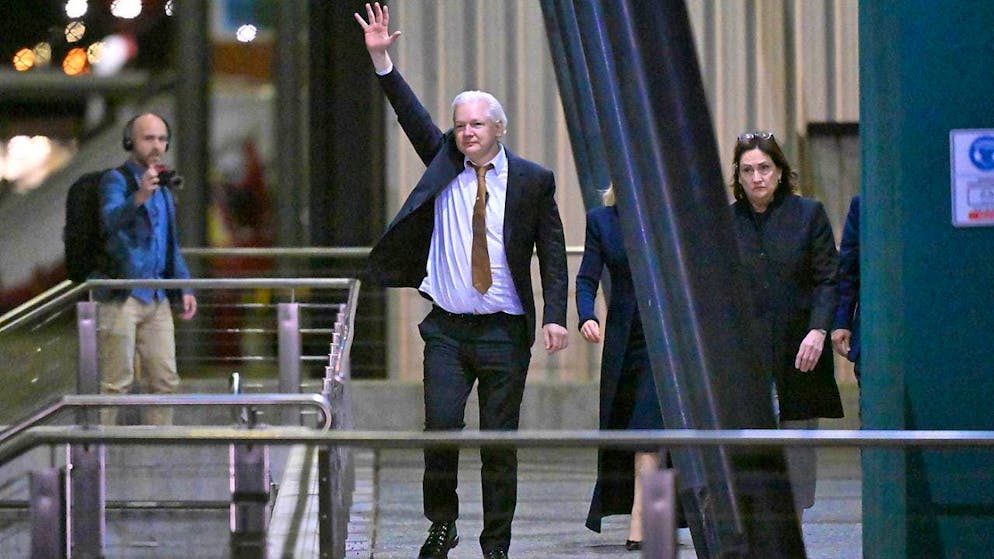 WikiLeaks founder Julian Assange waves after landing at RAAF Fairbairn airbase in Canberra. Assange has returned to his native Australia aboard a charter plane, hours after pleading guilty to obtaining and publishing US military secrets as part of a plea deal with Justice Department prosecutors. Photo: Mick Tsikas/AAP/dpa