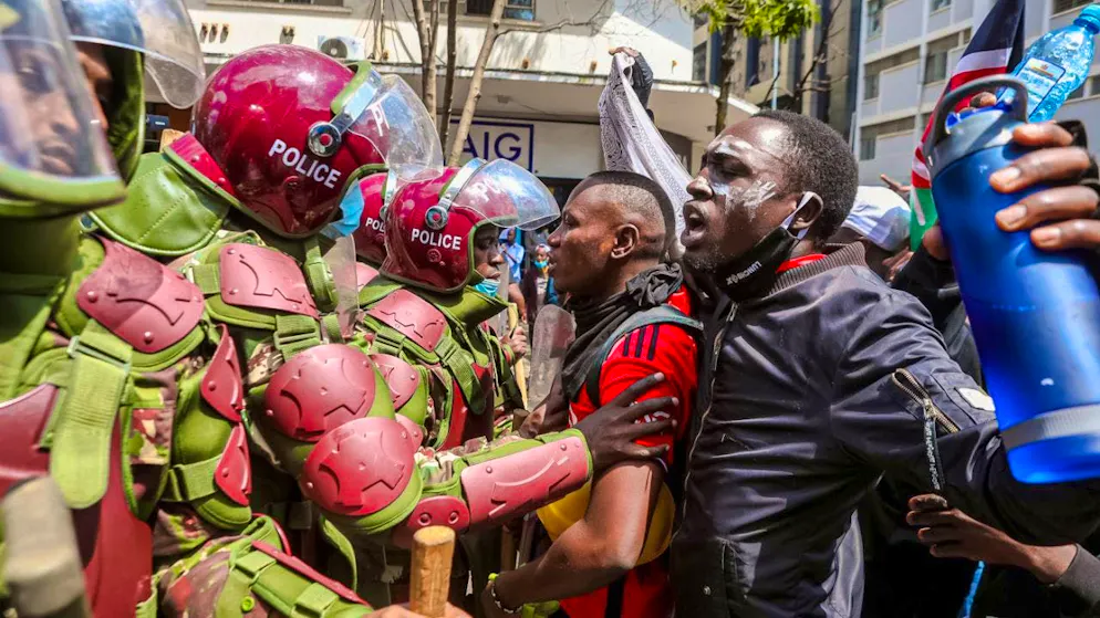 dpatopbilder - Police officers try to push people back during a demonstration in Nairobi. Hundreds of demonstrators stormed the parliament and set part of the building on fire. In a special session, the Kenyan parliament has now approved the deployment of the military in the protests that have been going on for days. Photo: Boniface Muthoni/SOPA Images via ZUMA Press Wire/dpa