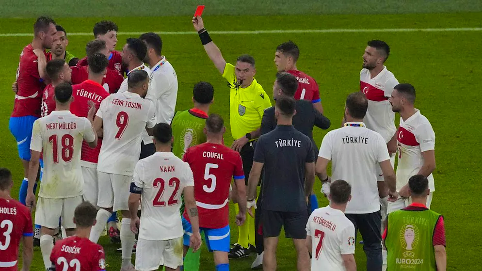 Referee Istvan Kovacs has a lot to do in the rough game between Turkey and the Czech Republic