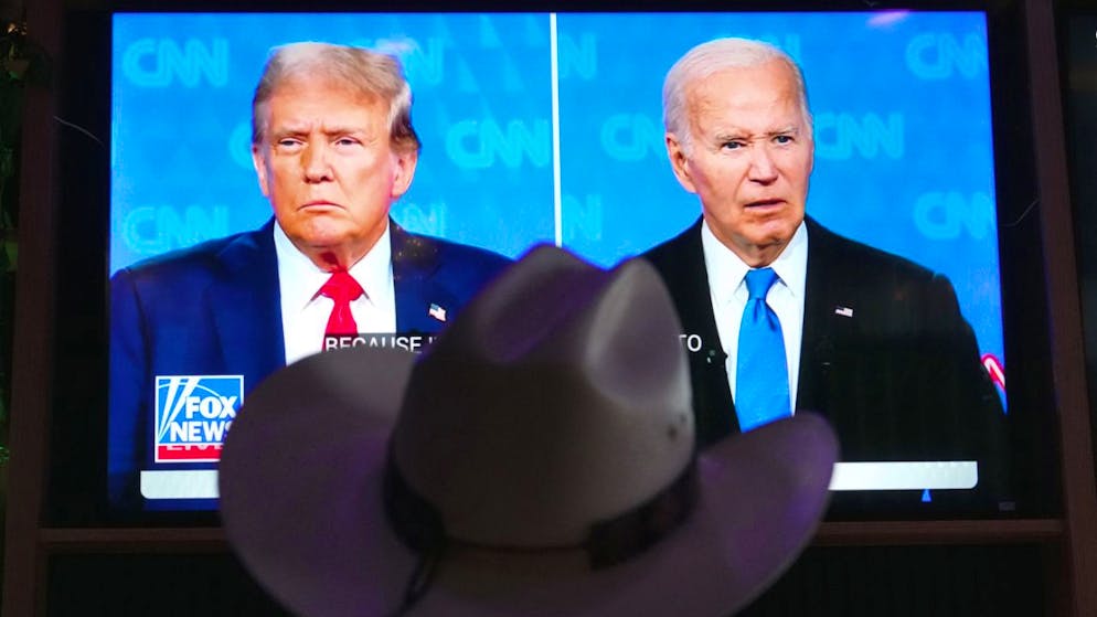 Un telespettatore guarda allo schermo il dibattito che ha visto opporsi ieri sera (questa notte in Svizzera) i due candidati alla Casa Bianca, il presidente degli Stati Uniti in carica Joe Biden e il suo sfidante Donald Trump.