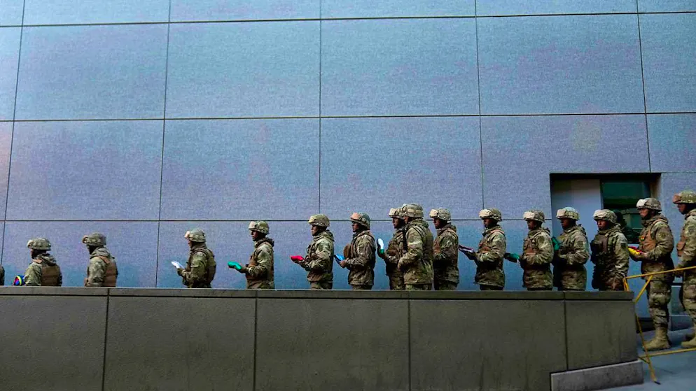 Soldiers retreat to the government palace after taking down the Bolivian national flag in Murillo Square in La Paz. Photo: Juan Karita/AP