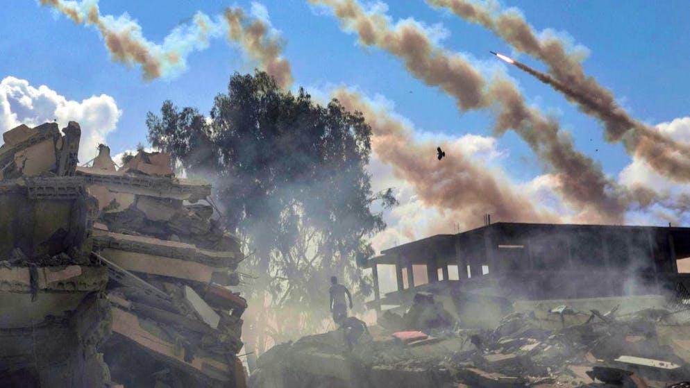 ARCHIVE - Rockets from the Gaza Strip are fired at Israel over destroyed buildings. Photo: Mohammed Dahman/AP/dpa