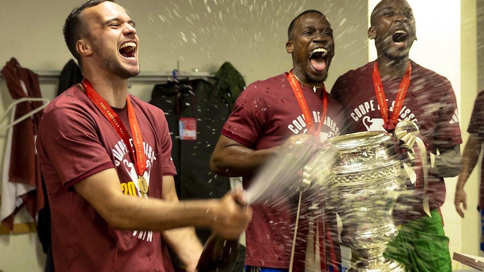 Servette players Jérémy Guillemenot (left), Dereck Kutesa (center) and Gaël Ondoua celebrate with the won Cup trophy