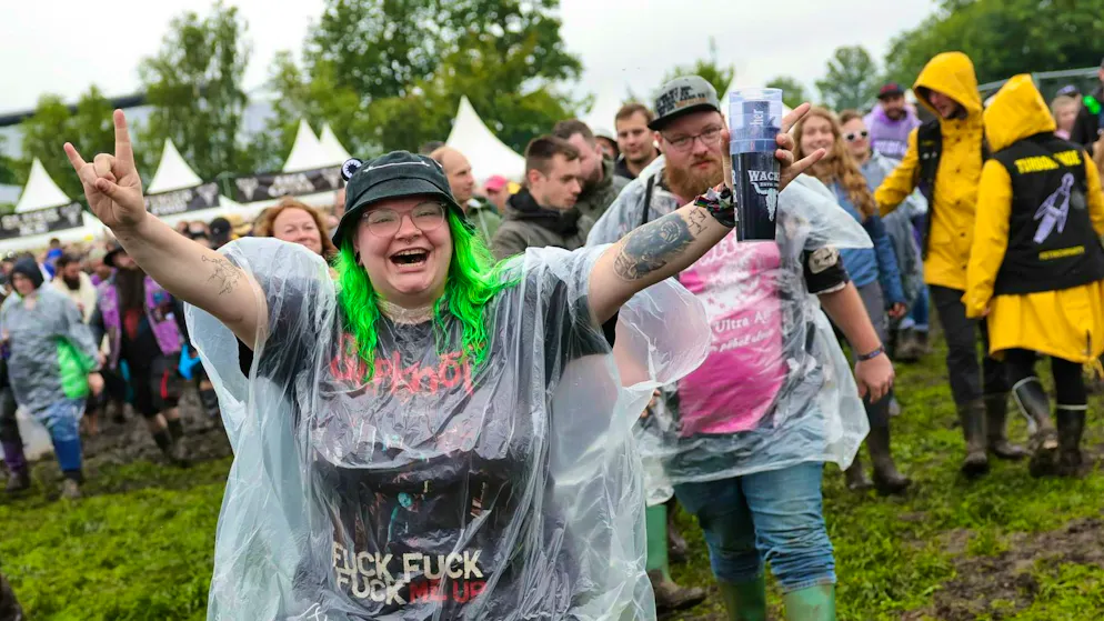 Metal fans run in front of the two main stages on the wet festival site after the opening of the so-called "infield"