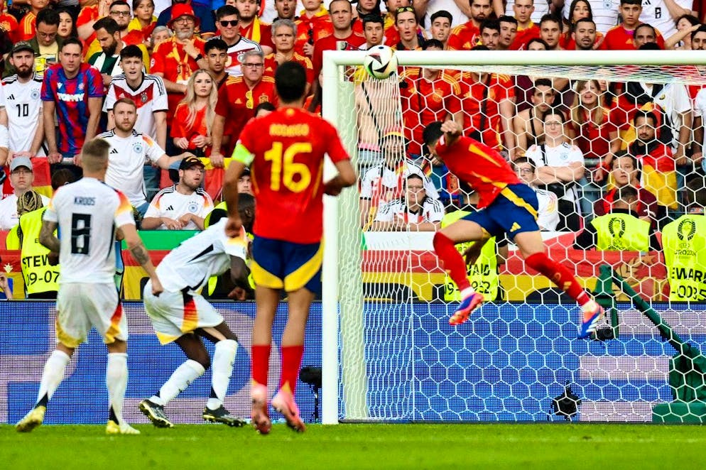 Spain's Mikel Merino rises highest and scores superbly into the far corner.